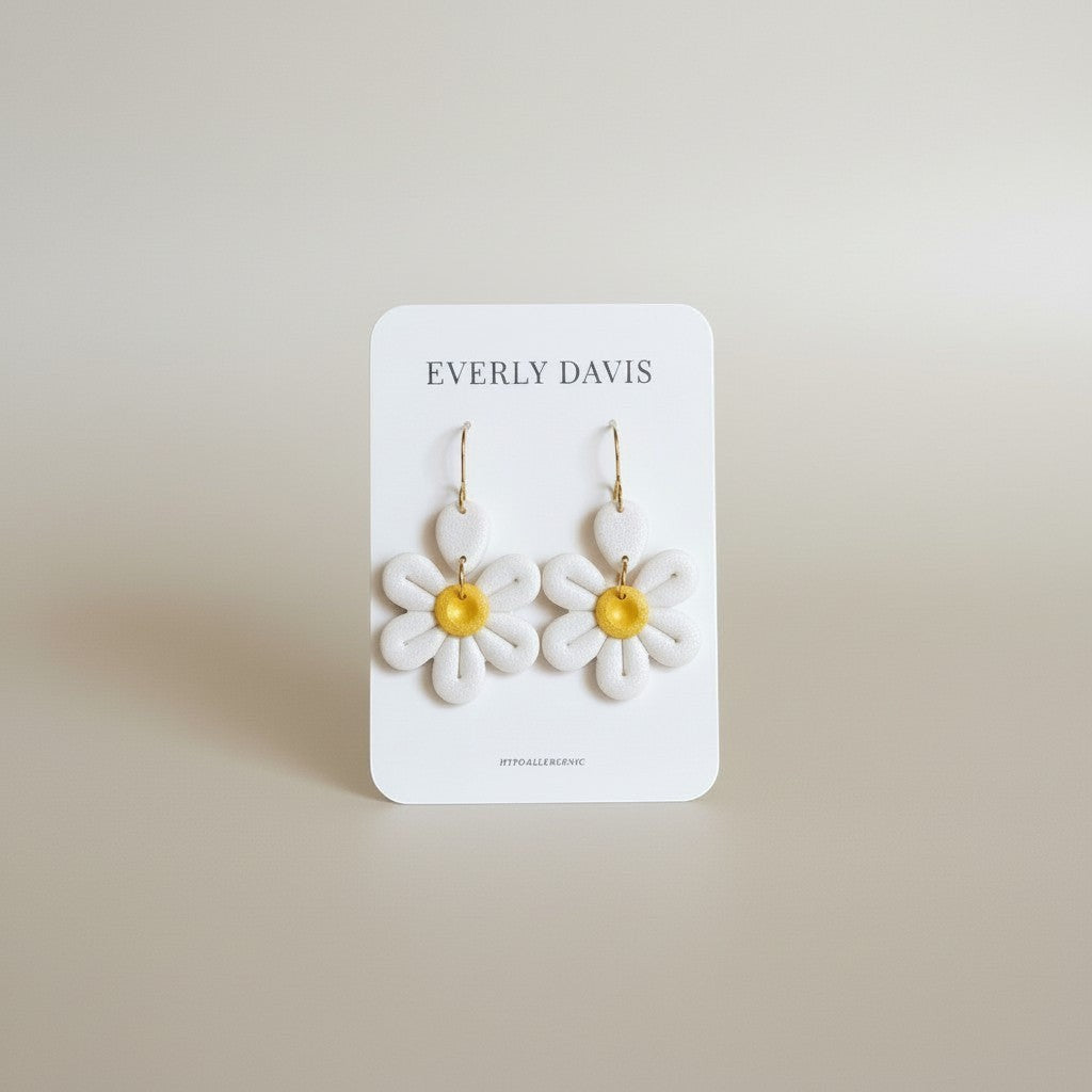Everly Davis white daisy clay earrings with yellow centers and gold hooks. Hypoallergenic.