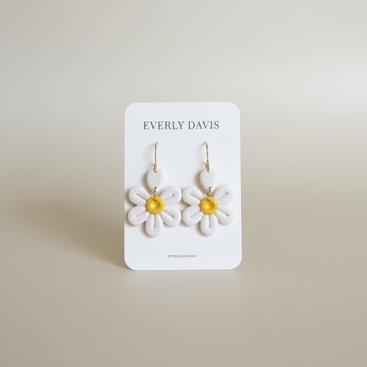 Everly Davis white daisy clay earrings with yellow centers and gold hooks. Hypoallergenic.