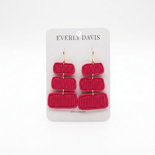 Everly Davis Pammi red clay dangle earrings with textured horizontal lines and gold hooks.