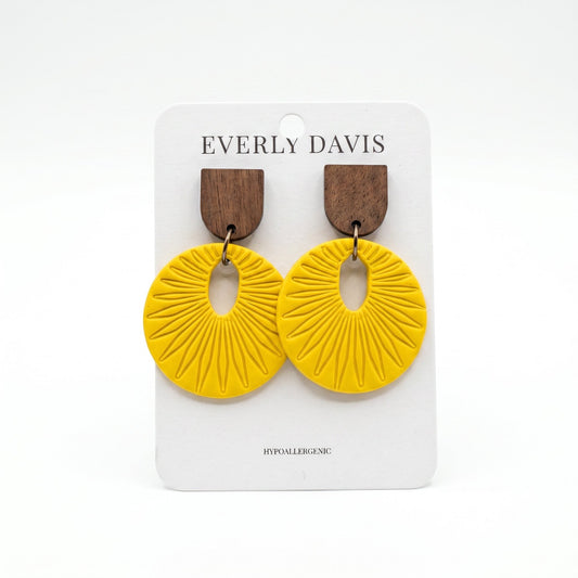 Everly Davis yellow circular drop earrings with dark wood studs and sunburst texture on a display card.