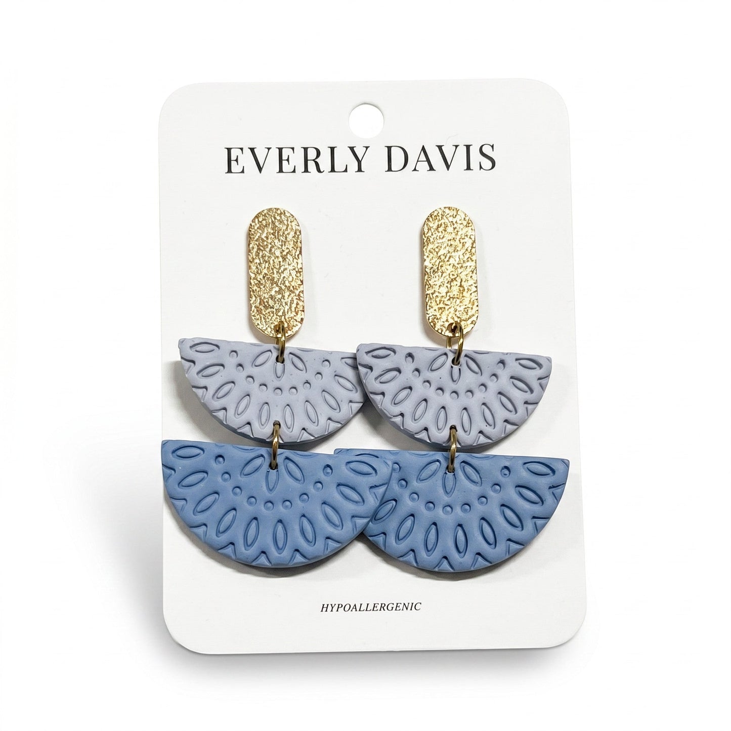 Everly Davis Annie earrings in light blue and periwinkle with gold textured posts. Dangle earrings with cutout floral pattern.