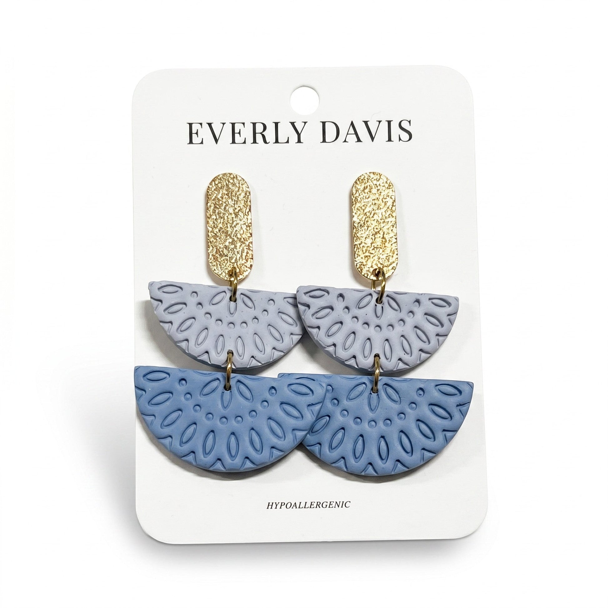 Everly Davis Annie earrings in light blue and periwinkle with gold textured posts. Dangle earrings with cutout floral pattern.