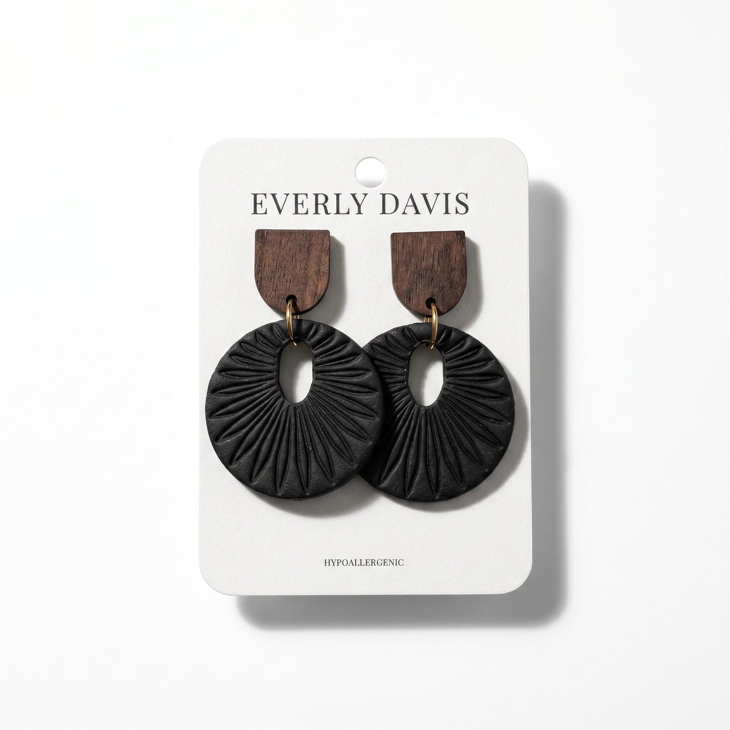 Everly Davis black circular drop earrings with dark wood studs and sunburst-inspired textured imprint.