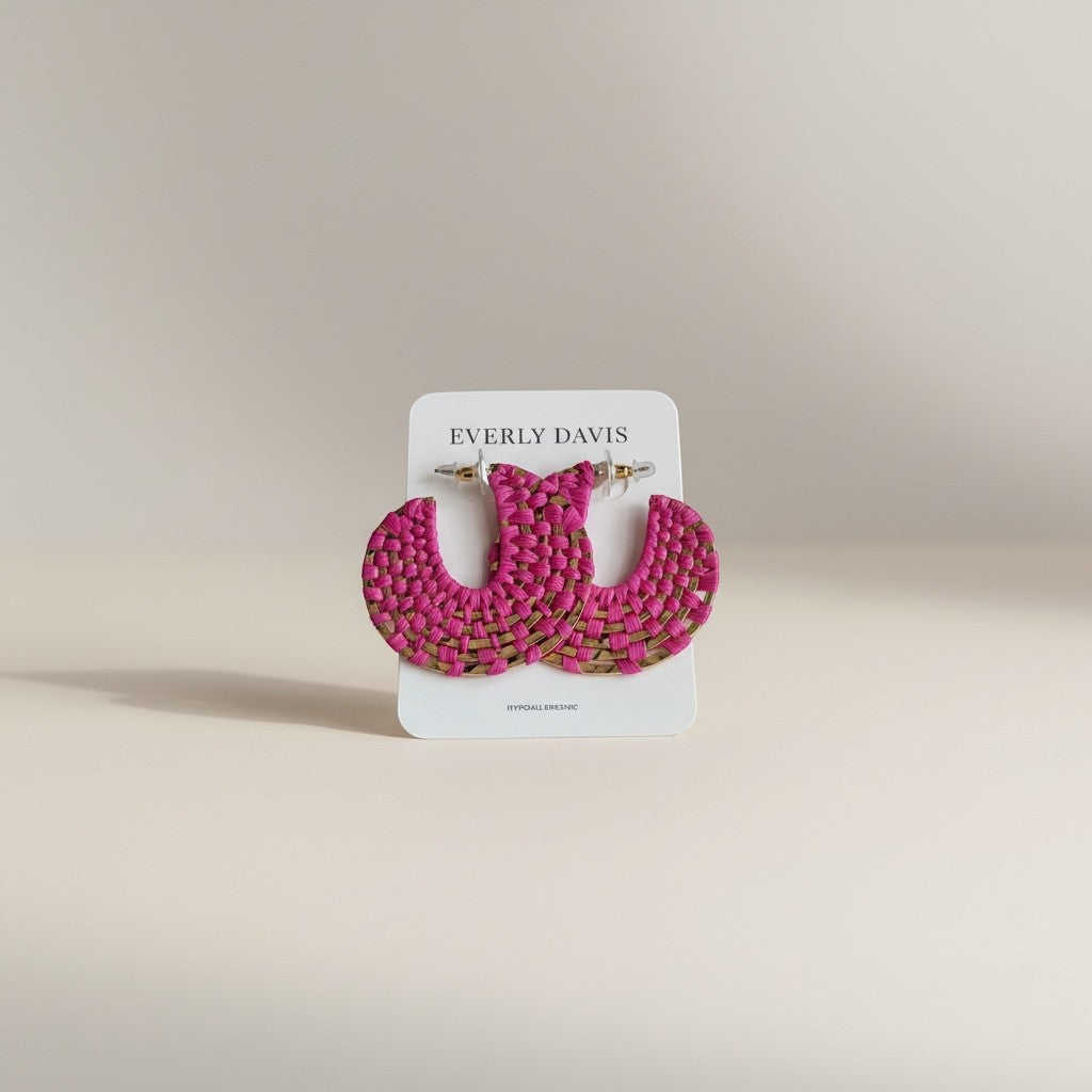 Everly Davis Disc Woven Raffia Hoops in bright pink, 2-inch diameter, featuring natural raffia woven onto metal disks.