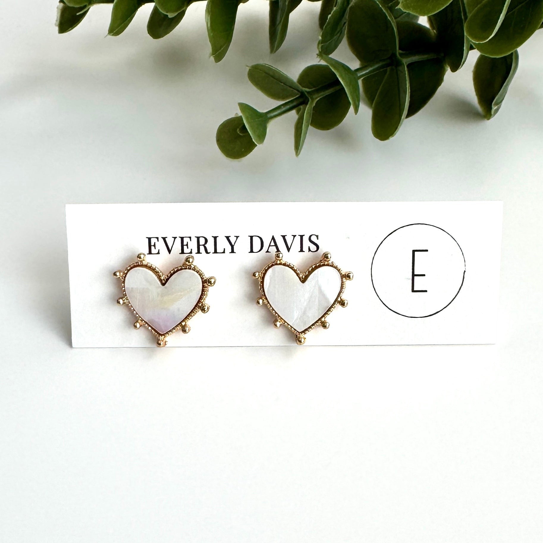 Everly Davis white faux pearl heart stud earrings with gold dotted trim and secure post backs.