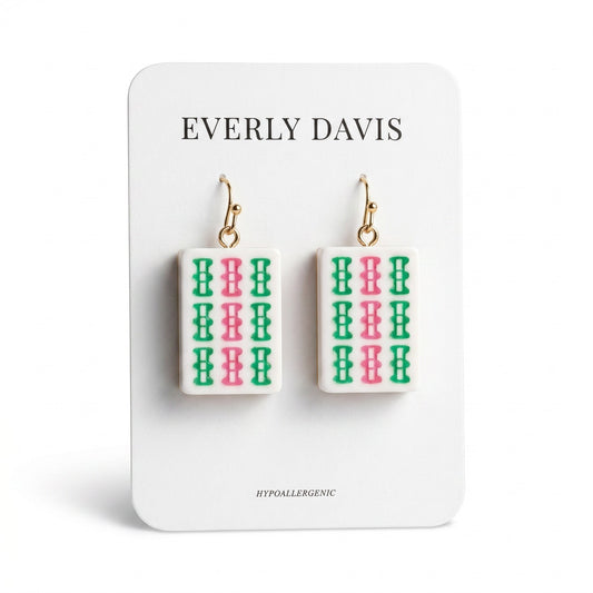Everly Davis white acrylic drop earrings with green and pink Mahjong tile pattern. Hypoallergenic gold-tone hooks.