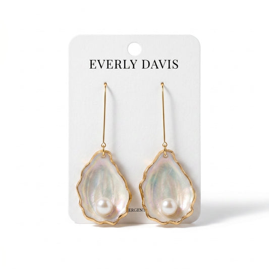 Everly Davis handmade oyster shell earrings with clay pearls, featuring iridescent blues, greens, and purples.