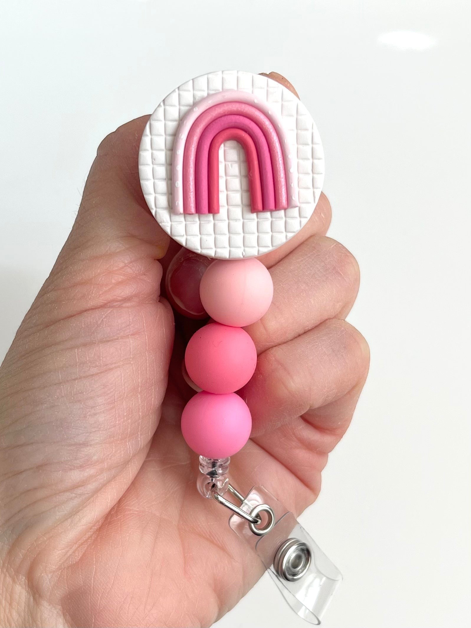 Everly Davis pink rainbow beaded badge reel with silicone beads and alligator clip.