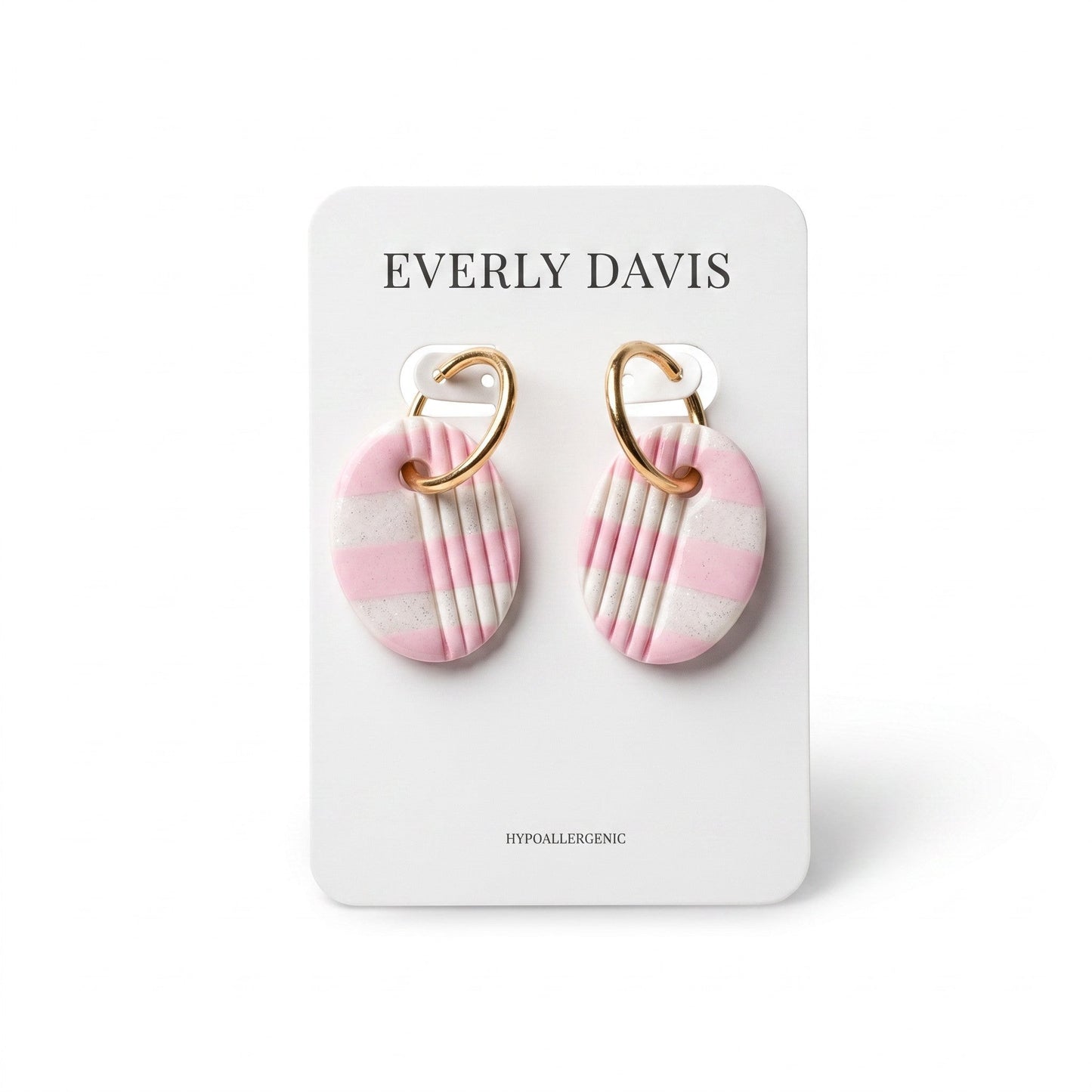 Everly Davis oval clay earrings with pink and white stripes and gold huggie hoops.