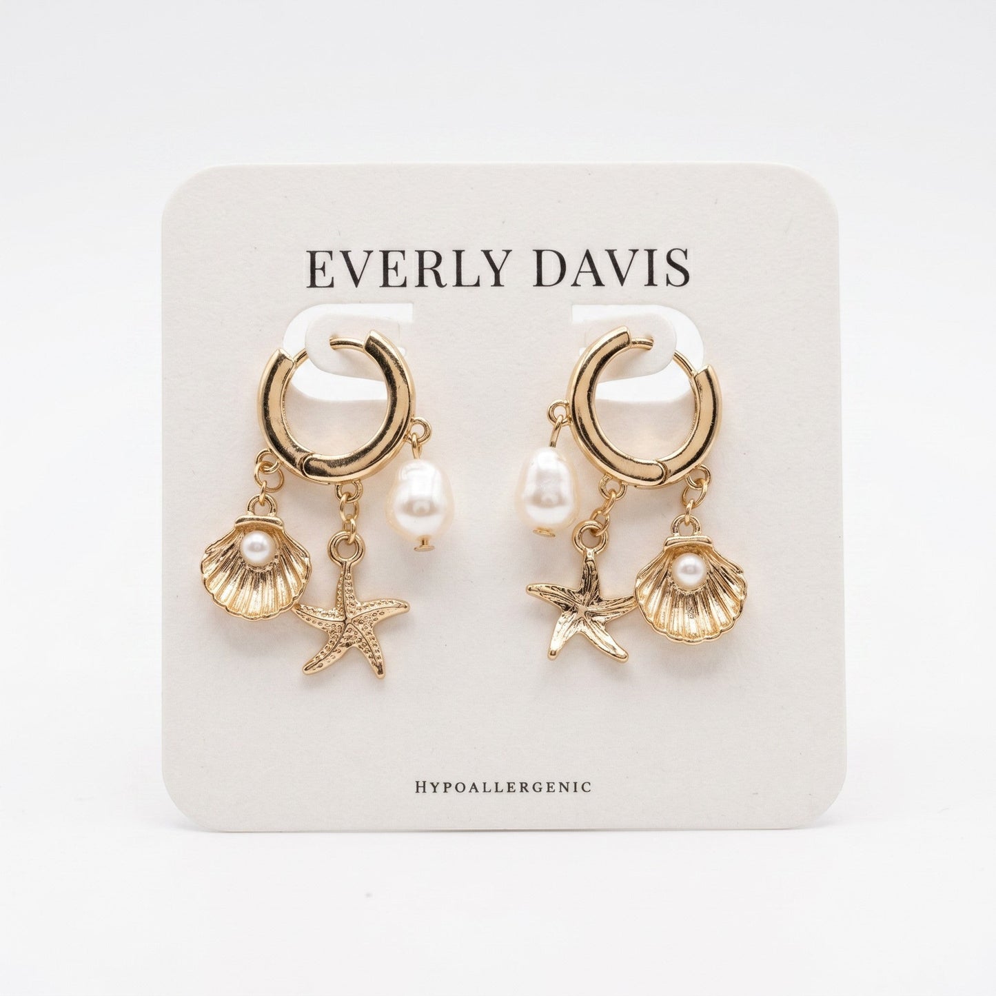 Everly Davis gold huggie earrings with faux pearl, seashell, and starfish charms. Hypoallergenic.