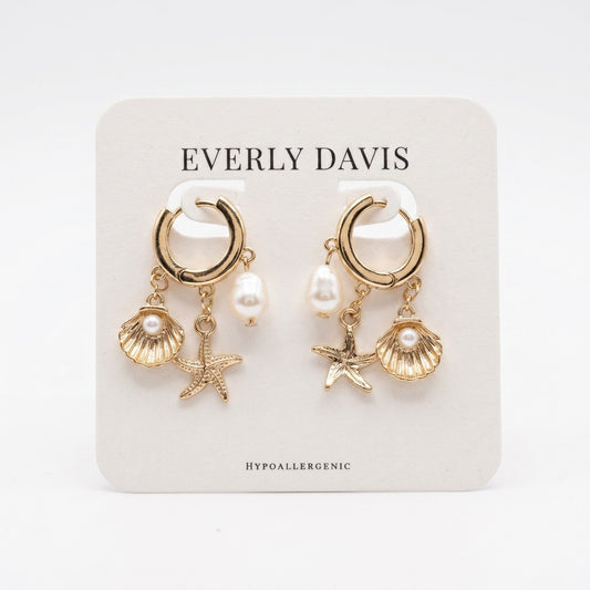 Everly Davis gold huggie earrings with faux pearl, seashell, and starfish charms. Hypoallergenic.