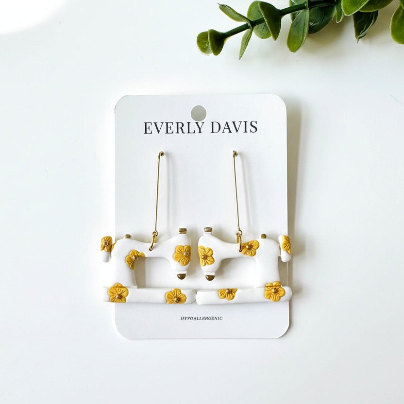 Everly Davis white sewing machine dangle earrings with yellow floral accents. Hypoallergenic.