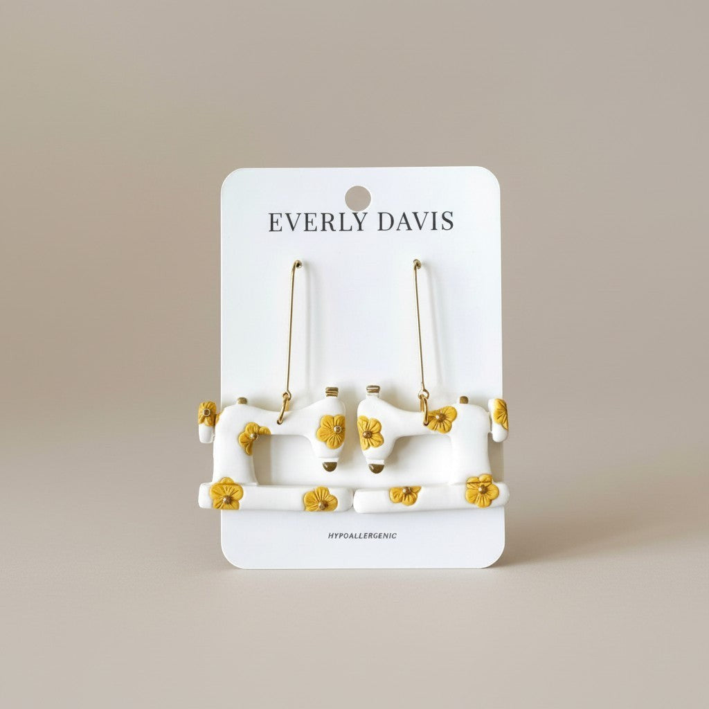 Everly Davis white dangle earrings shaped like sewing machines with yellow floral accents. Hypoallergenic.