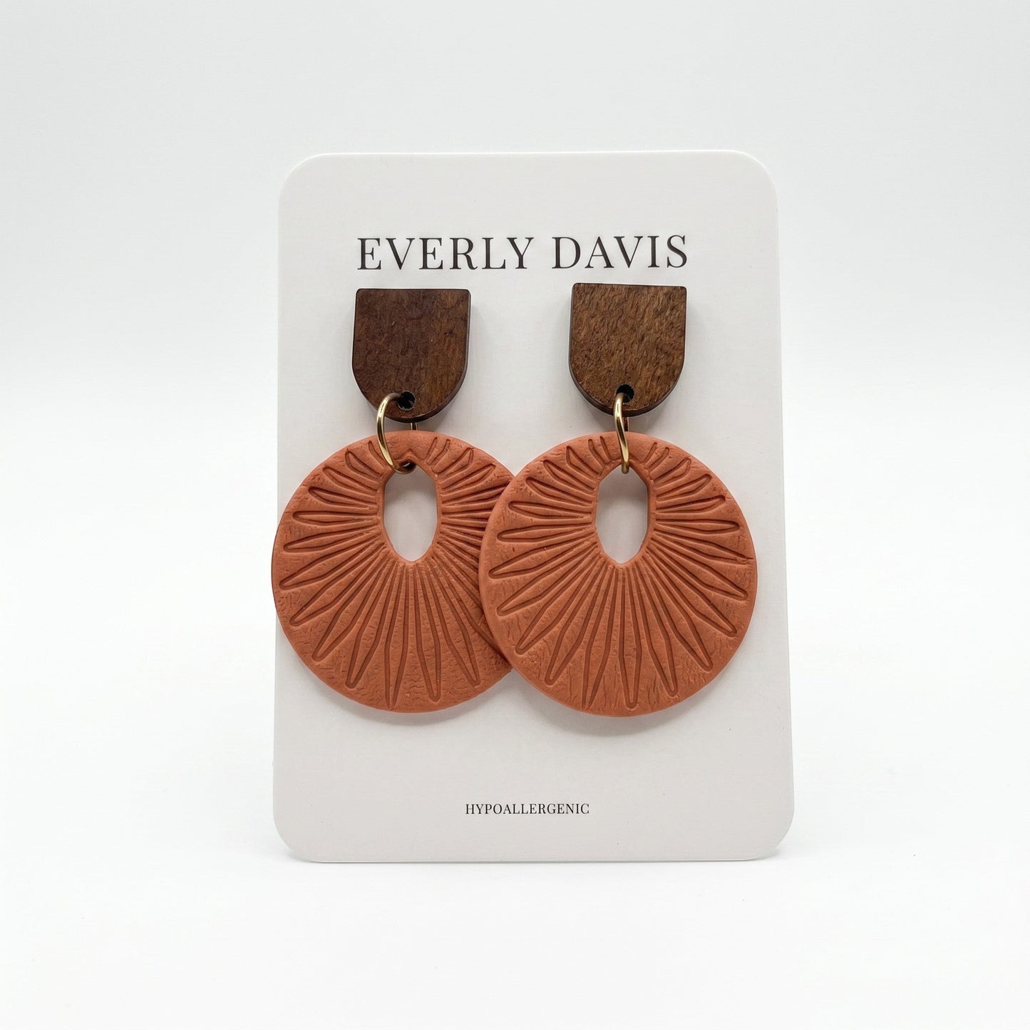 Everly Davis terracotta circular drop earrings with dark wood studs and sunburst texture on a display card.
